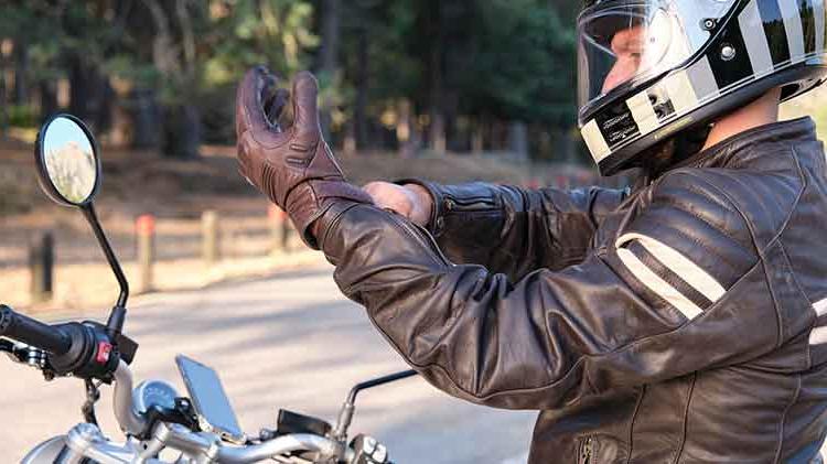 Motorcycle rider putting on a motorcycle glove